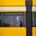 Draufsicht auf eine vorbeifahrende gelbe Straßenbahn.