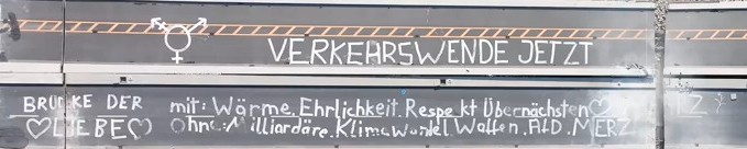 Ein Teil der eingestürzten Carolabrücke in Dresden von oben. Auf der Fahrbahn steht: "Verkehrswende jetzt. Brücke der Liebe. Mit: Wärme, Ehrlichkeit, Respekt übernächsten März. Ohne: Milliardäre, Klimawandel, Waffen, AfD, Merz.